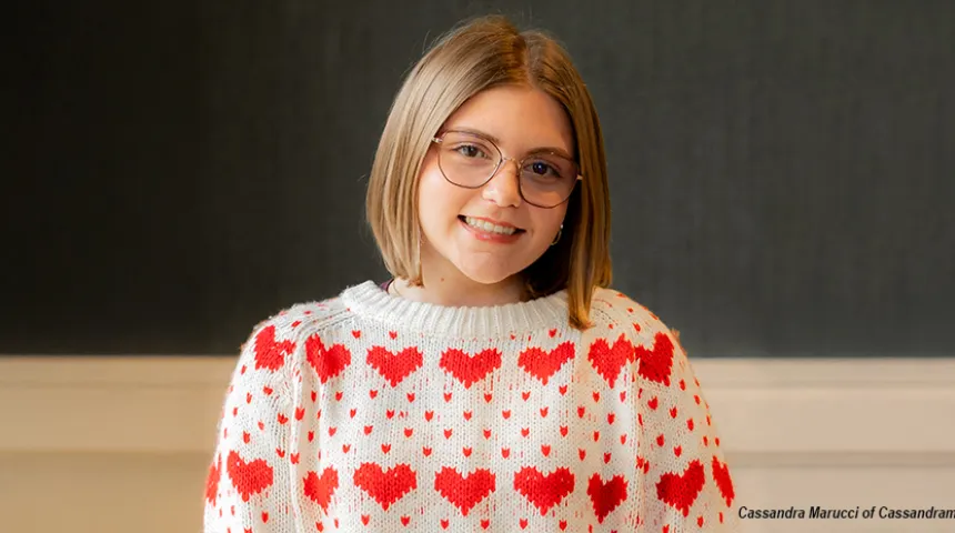Adelaide Greenwald, looking at the camera, wearing a white sweater with a red heart pattern.