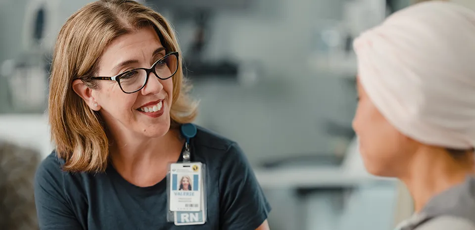 A smiling nurse is talking to a patient.