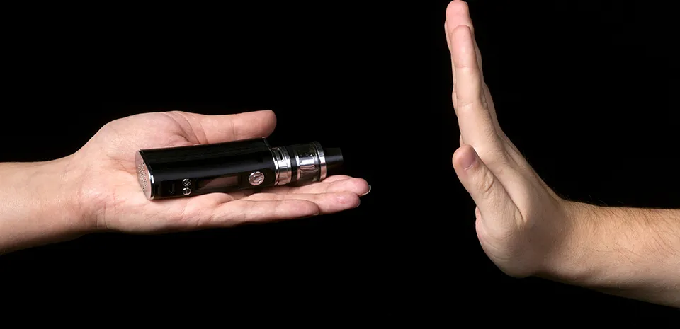 hand gesturing to stop quitting tobacco by not taking an e-cigarette