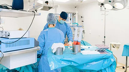 Photo of doctors in operating room performing robotic surgery on a patient