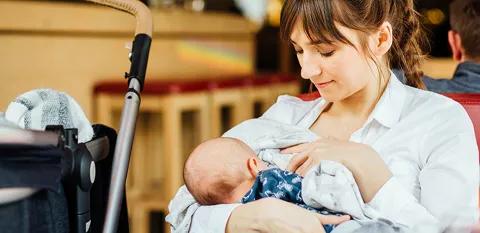 new mom breastfeeding newborn in public