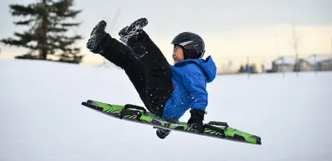 boy sledding in the snow