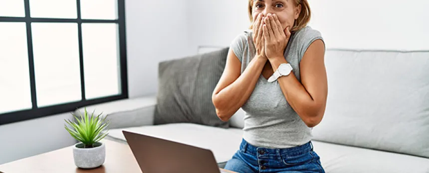 Woman covering her mouth looking embarassed